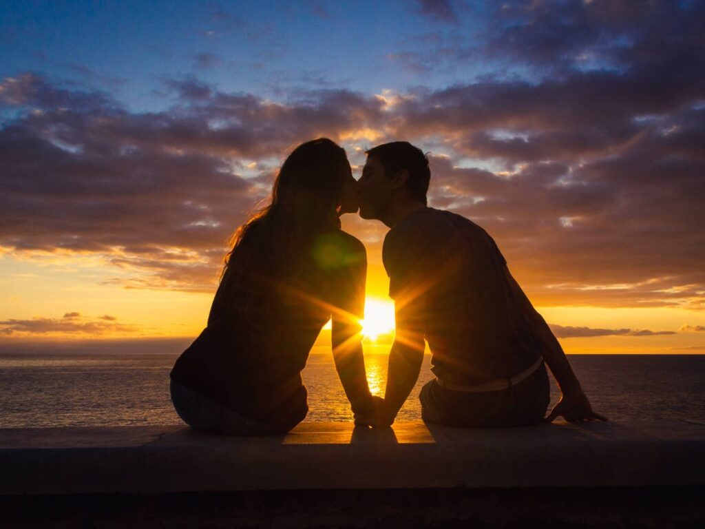 Personas besándose en una puesta de sol