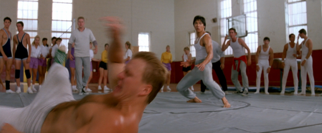 Bruce Lee luchando contra unos abusones en el gimnasio de la universidad