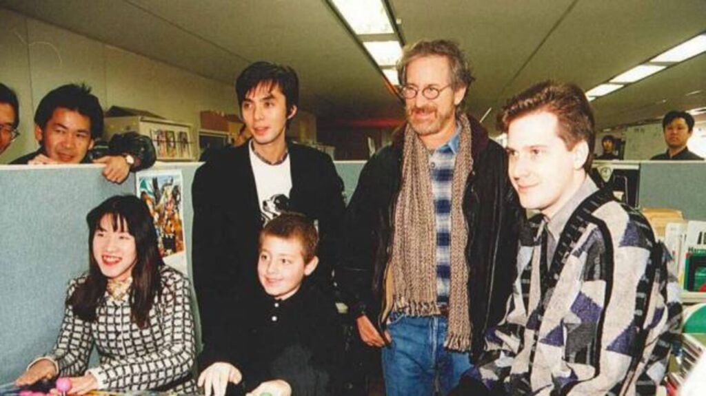 Yū Suzuki, Yūji Naka y Mark Cerny enseñando a Steven Spielberg y su hijo una demo del Virtual Fighter (1993)