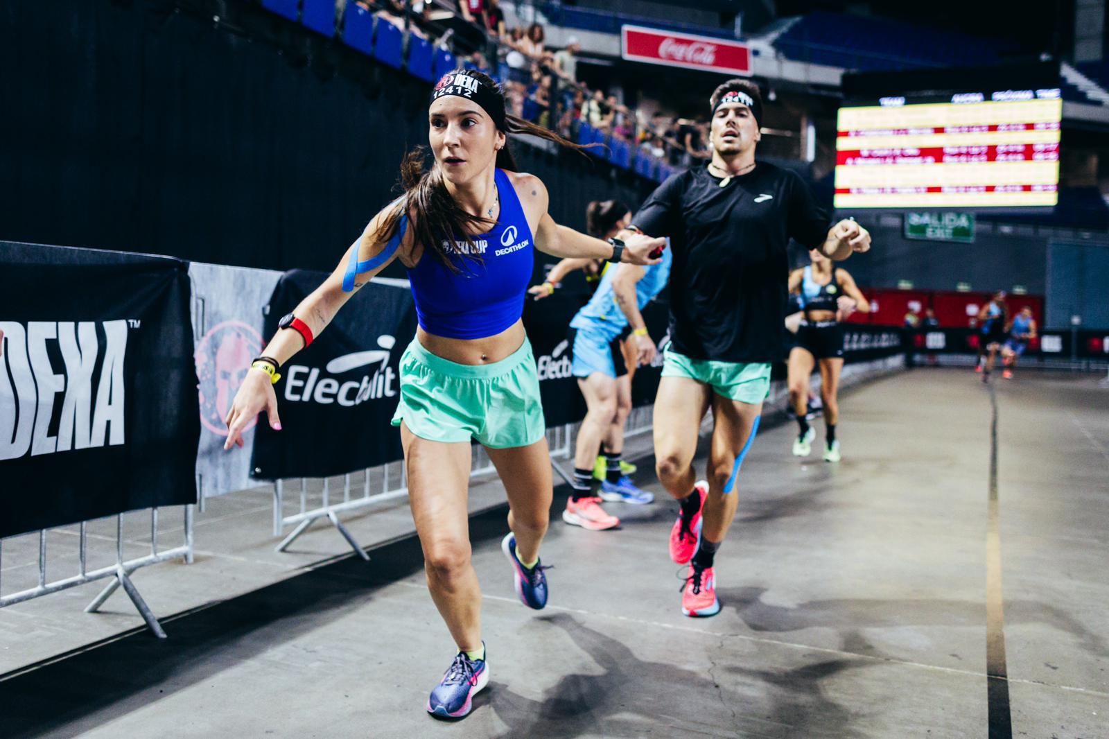 Atletas de la categoría de equipos mixtos pasando el relevo durante una fase de carrera