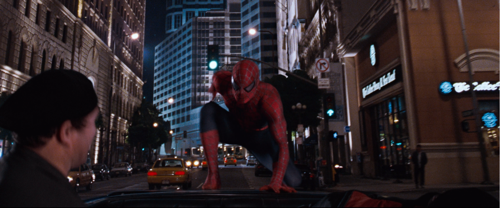 Spider-Man deteniendo a unos ladrones en un coche negro descapotable