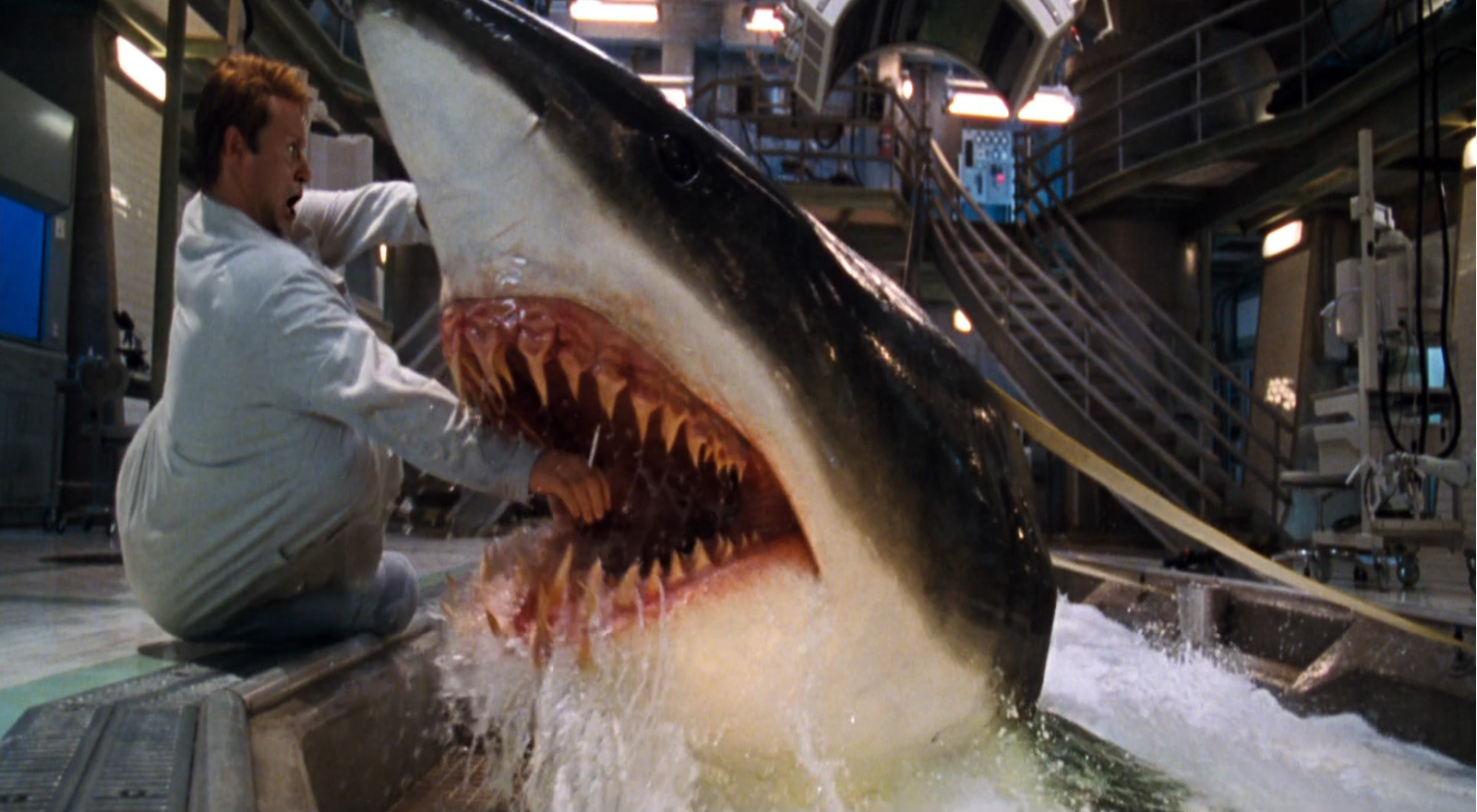 El Dr. Jim Whitlock siendo mordido por uno de los tiburones en Deep Blue Sea (1999) El Dr. Jim Whitlock siendo mordido por uno de los tiburones en Deep Blue Sea (1999)